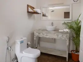 Exquisite bathroom adorned with a pristine toilet, elegant sink, and a gleaming mirror, exuding opulence and sophistication.