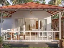 A picturesque white cottage, featuring an enchanting balcony and an exquisitely tiled roof.