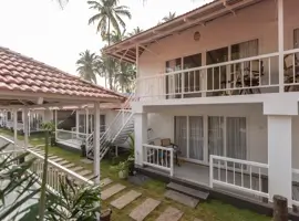 A beautiful beach suites in Palolem, Goa, surrounded by palm trees and overlooking the ocean.